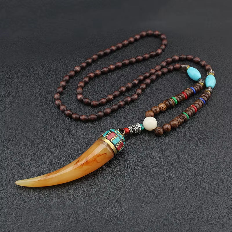 Necklace with wooden beads and a large tusk pendant on a dark background